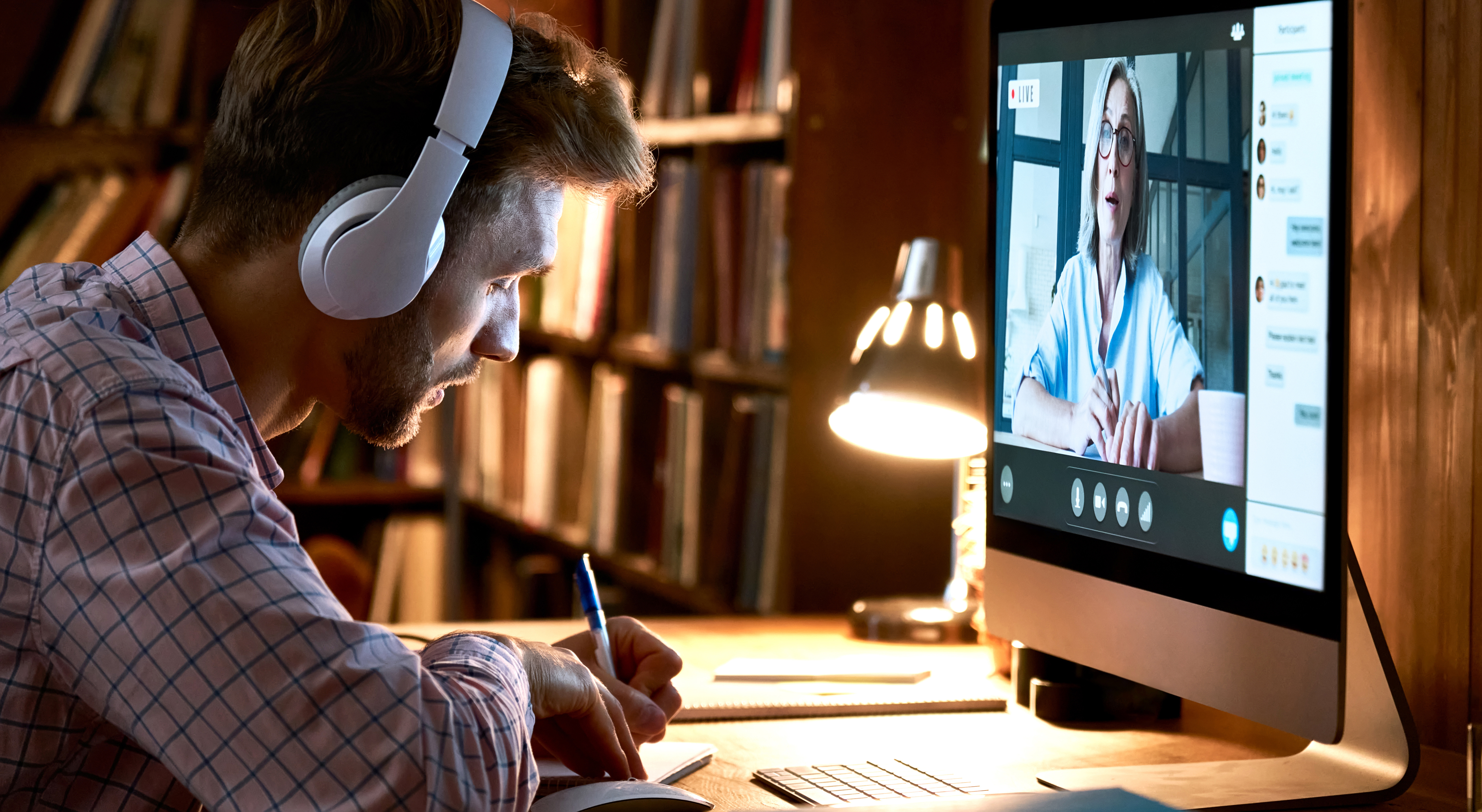 An RBT student takes notes from a pre-recorded instructional video on a desktop computer in the library.