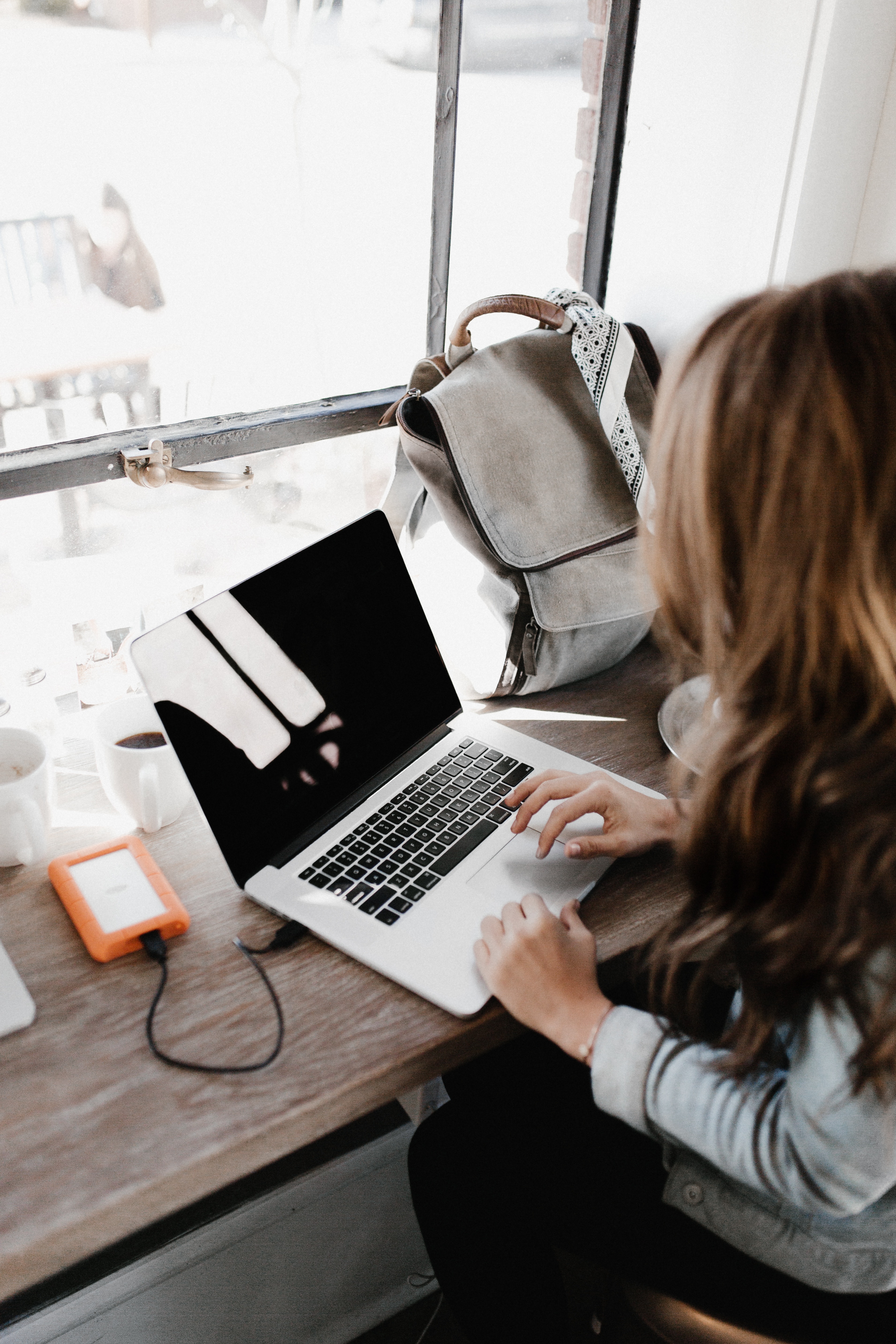 A registered behavior technician completes her live training on her laptop in front of a bright window.