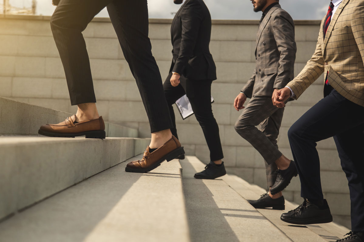 Fashionable young professionals ascend a set of stone stairs to their next challenge.