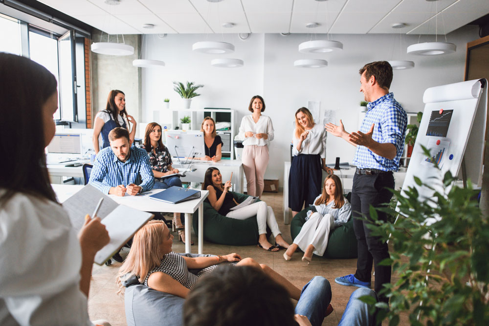 A cheerful group of hardworking registered behavior technicians gather to meet and brainstorm their next task in a bright office.